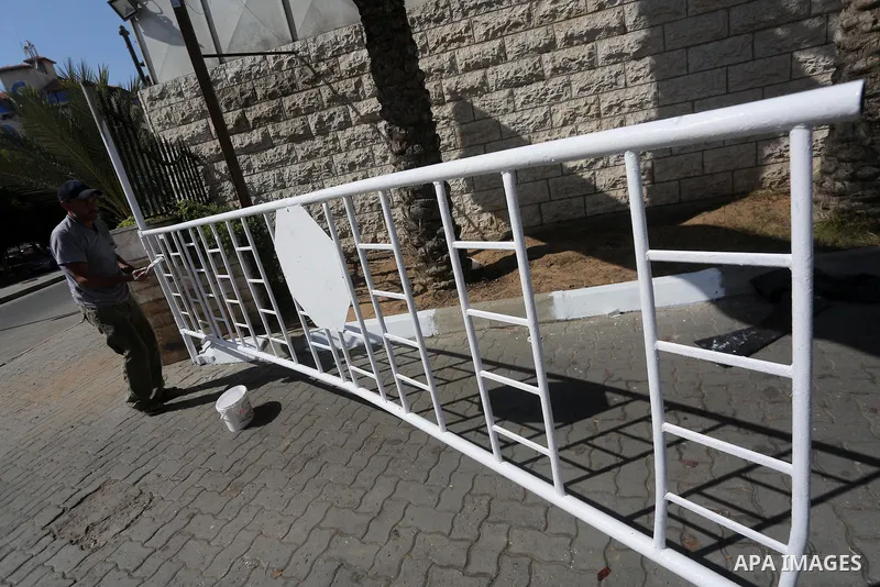 Palestinian workers clean outside the Palestinian cabinet headquarters in Gaza City on October 1, 2017. Photo by Mohammed Asad