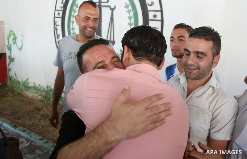 A member of the Palestinian Fatah movement, is greeted by a relative in Gaza City after his release from a Hamas-run jail as part of reconciliation efforts on October 1, 2017. Photo by Hassan Jedi