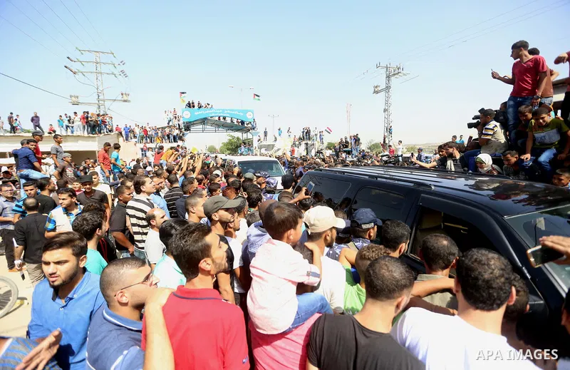 Palestinians gather as the convoy of Palestinian Prime Minister Rami Hamdallah and his government ministers arrives to Erez crossing in the northern Gaza Strip, on October 2, 2017. Hamdallah is on on his first visit to t...