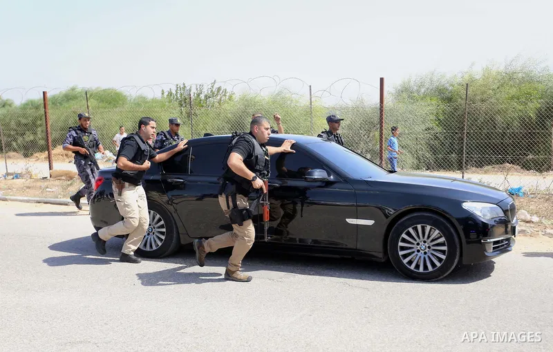 Palestinian security officers surround the vehicle carrying Prime Minister Rami Hamdallah upon his arrival with his government at Erez crossing in the northern Gaza Strip, on October 2, 2017. Hamdallah is on on his first...