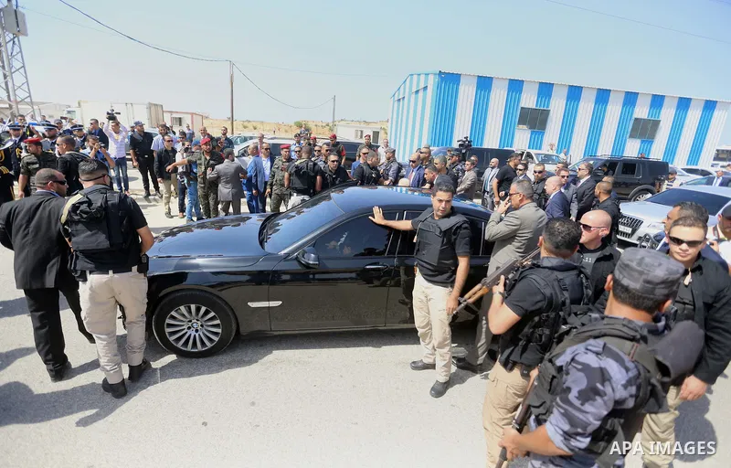 Palestinian security officers surround the vehicle carrying Prime Minister Rami Hamdallah upon his arrival with his government at Erez crossing in the northern Gaza Strip, on October 2, 2017. Hamdallah is on on his first...