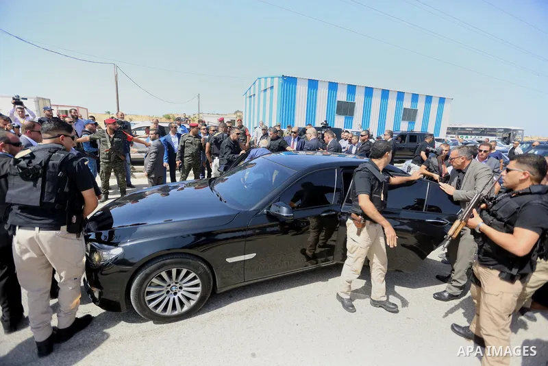 Palestinian security officers surround the vehicle carrying Prime Minister Rami Hamdallah upon his arrival with his government at Erez crossing in the northern Gaza Strip, on October 2, 2017. Hamdallah is on on his first...