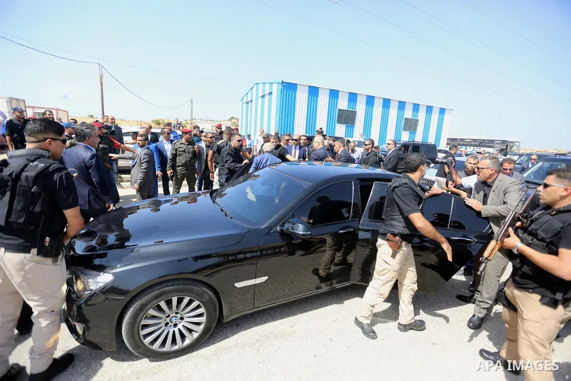 Palestinian security officers surround the vehicle carrying Prime Minister Rami Hamdallah upon his arrival with his government at Erez crossing in the northern Gaza Strip, on October 2, 2017. Hamdallah is on on his first...