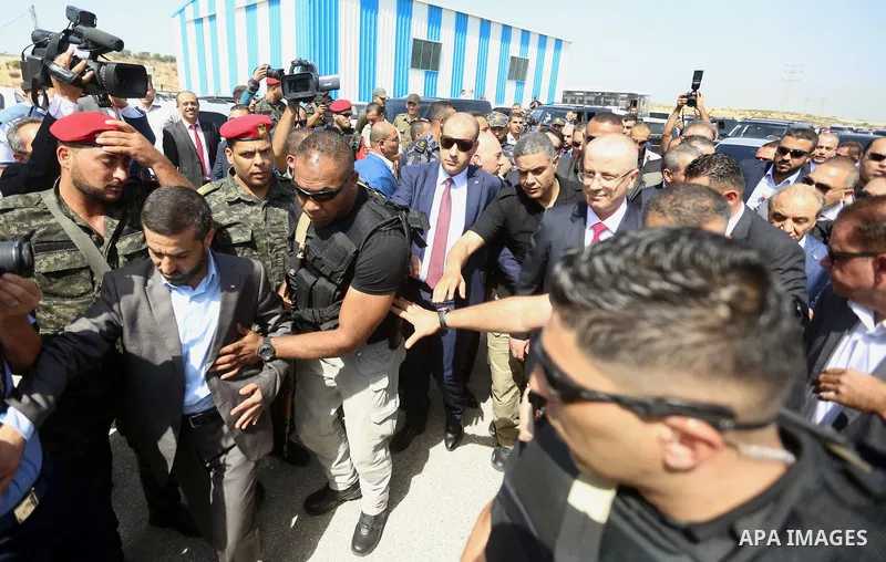 Palestinian prime minister Rami Hamdallah is surrounded by security as he arrives at the Erez border crossing in the northern Gaza Strip on October 2, 2017. Hamdallah is on on his first visit to the Gaza Strip for talks...