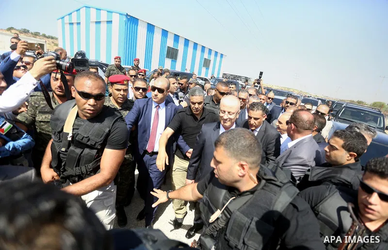 Palestinian prime minister Rami Hamdallah is surrounded by security as he arrives at the Erez border crossing in the northern Gaza Strip on October 2, 2017. Hamdallah is on on his first visit to the Gaza Strip for talks...