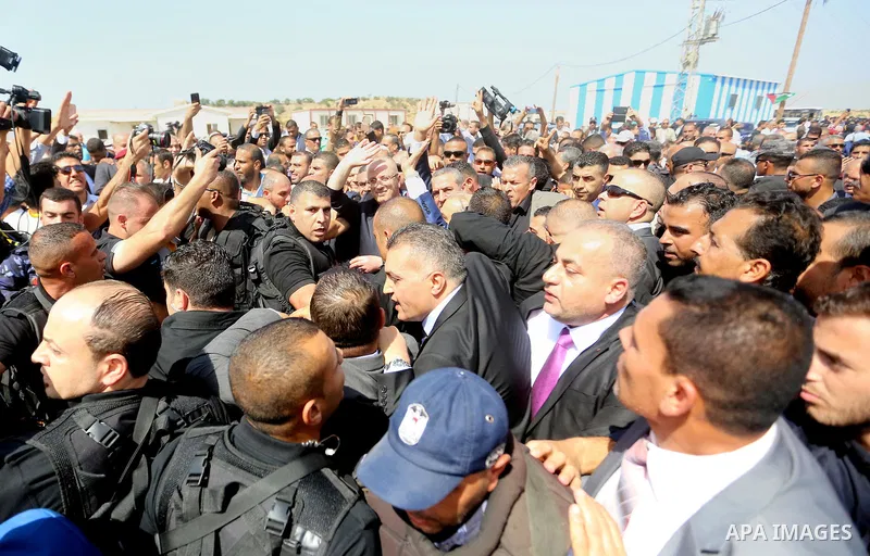 Palestinian Prime Minister Rami Hamdallah is surrounded by security as he waves following his arrival at the Erez border crossing in the northern Gaza Strip on October 2, 2017. Hamdallah is on on his first visit to the G...