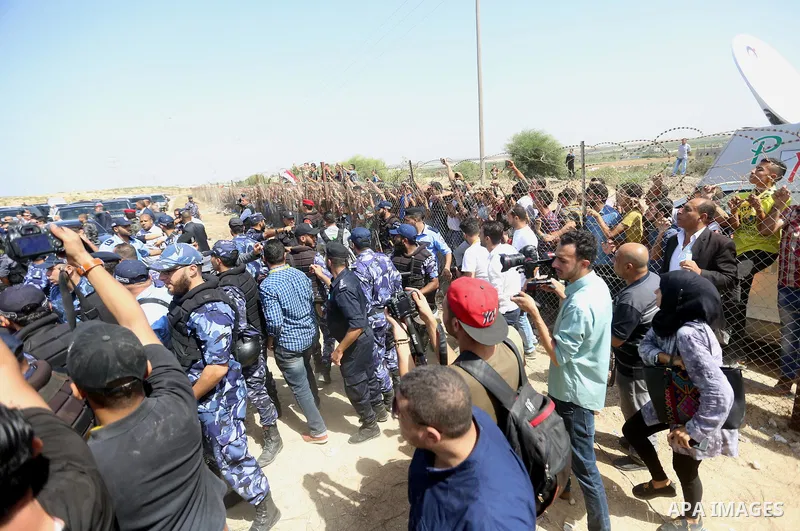 Palestinian Policemen try to hold back the crowd as the convoy of Palestinian Prime Minister Rami Hamdallah arrives to the Erez border crossing in the northern Gaza Strip on October 2, 2017. Hamdallah is on on his first...