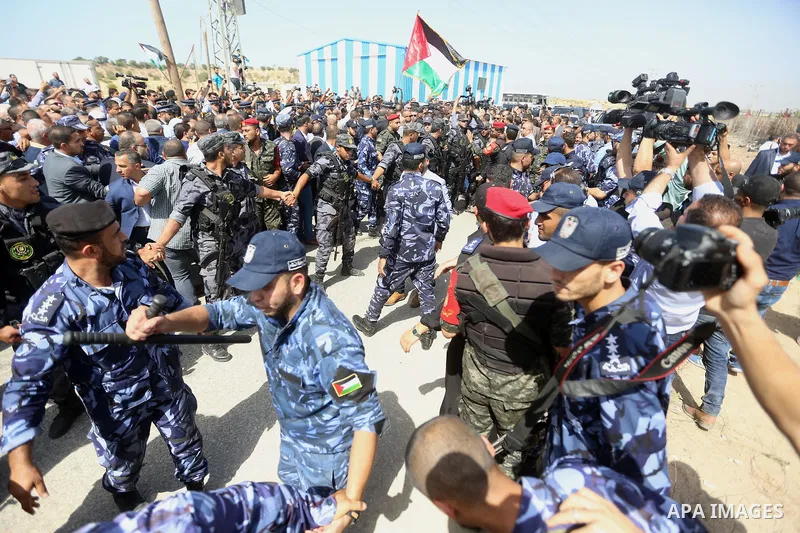Palestinian Policemen try to hold back the crowd as the convoy of Palestinian Prime Minister Rami Hamdallah arrives to the Erez border crossing in the northern Gaza Strip on October 2, 2017. Hamdallah is on on his first...