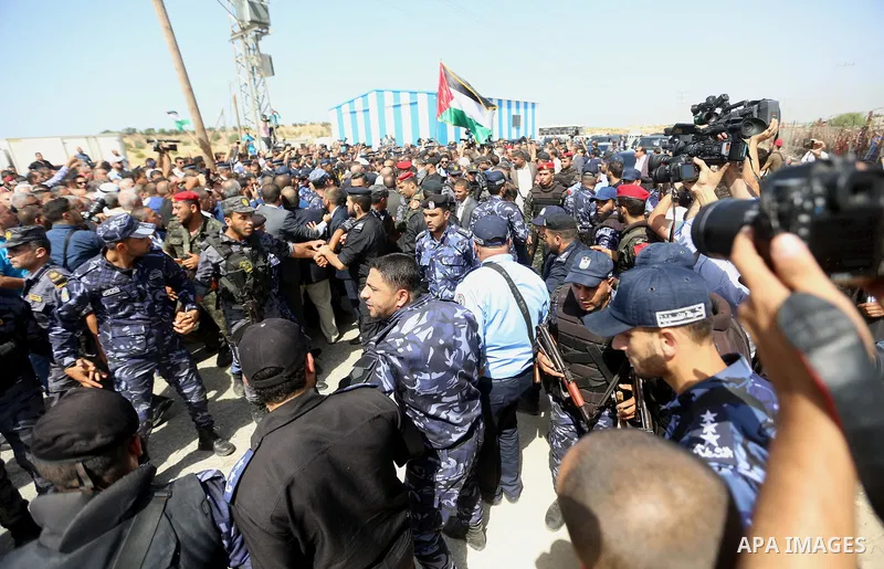 Palestinian Policemen try to hold back the crowd as the convoy of Palestinian Prime Minister Rami Hamdallah arrives to the Erez border crossing in the northern Gaza Strip on October 2, 2017. Hamdallah is on on his first...