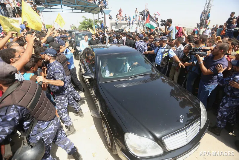 Palestinians celebrate as the convoy of Palestinian Prime Minister Rami Hamdallah and his government ministers arrive to the Erez border crossing in the northern Gaza Strip on October 2, 2017. Hamdallah is on on his firs...