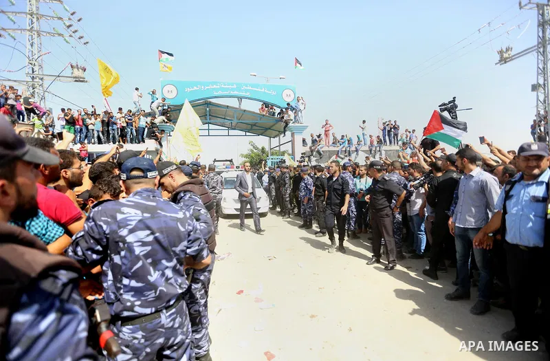 Palestinians celebrate as the convoy of Palestinian Prime Minister Rami Hamdallah and his government ministers arrive to the Erez border crossing in the northern Gaza Strip on October 2, 2017. Hamdallah is on on his firs...