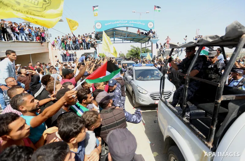 Palestinians celebrate as the convoy of Palestinian Prime Minister Rami Hamdallah and his government ministers arrive to the Erez border crossing in the northern Gaza Strip on October 2, 2017. Hamdallah is on on his firs...