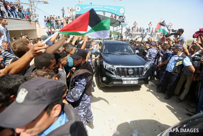 Palestinians celebrate as the convoy of Palestinian Prime Minister Rami Hamdallah and his government ministers arrive to the Erez border crossing in the northern Gaza Strip on October 2, 2017. Hamdallah is on on his firs...