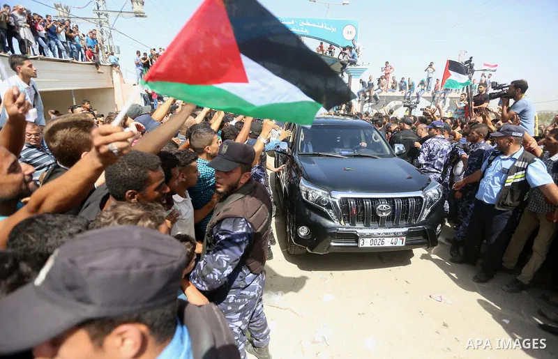 Palestinians celebrate as the convoy of Palestinian Prime Minister Rami Hamdallah and his government ministers arrive to the Erez border crossing in the northern Gaza Strip on October 2, 2017. Hamdallah is on on his firs...