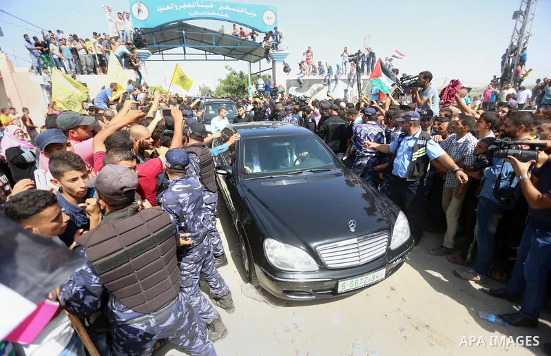 Palestinians celebrate as the convoy of Palestinian Prime Minister Rami Hamdallah and his government ministers arrive to the Erez border crossing in the northern Gaza Strip on October 2, 2017. Hamdallah is on on his firs...