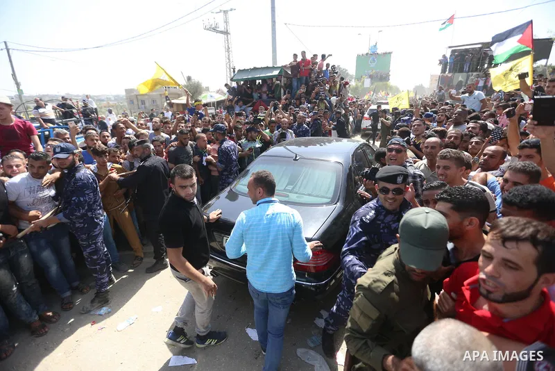 Palestinians celebrate as the convoy of Palestinian Prime Minister Rami Hamdallah and his government ministers arrive to the Erez border crossing in the northern Gaza Strip on October 2, 2017. Hamdallah is on on his firs...