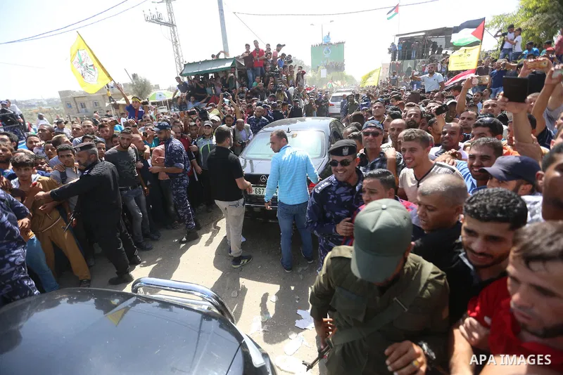 Palestinians celebrate as the convoy of Palestinian Prime Minister Rami Hamdallah and his government ministers arrive to the Erez border crossing in the northern Gaza Strip on October 2, 2017. Hamdallah is on on his firs...
