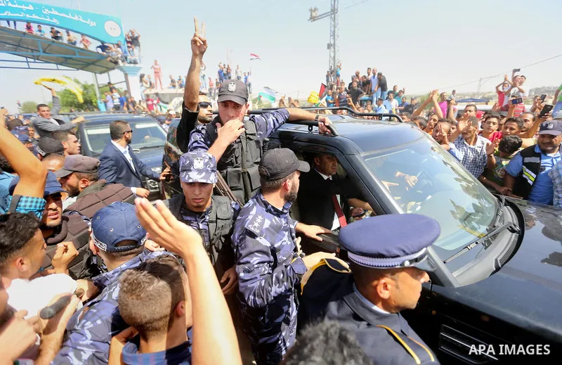 Palestinians celebrate as the convoy of Palestinian Prime Minister Rami Hamdallah and his government ministers arrive to the Erez border crossing in the northern Gaza Strip on October 2, 2017. Hamdallah is on on his firs...