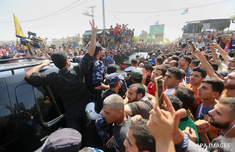 Palestinians celebrate as the convoy of Palestinian Prime Minister Rami Hamdallah and his government ministers arrive to the Erez border crossing in the northern Gaza Strip on October 2, 2017. Hamdallah is on on his firs...