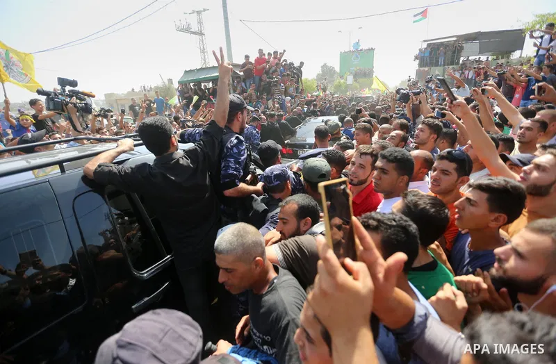 Palestinians celebrate as the convoy of Palestinian Prime Minister Rami Hamdallah and his government ministers arrive to the Erez border crossing in the northern Gaza Strip on October 2, 2017. Hamdallah is on on his firs...