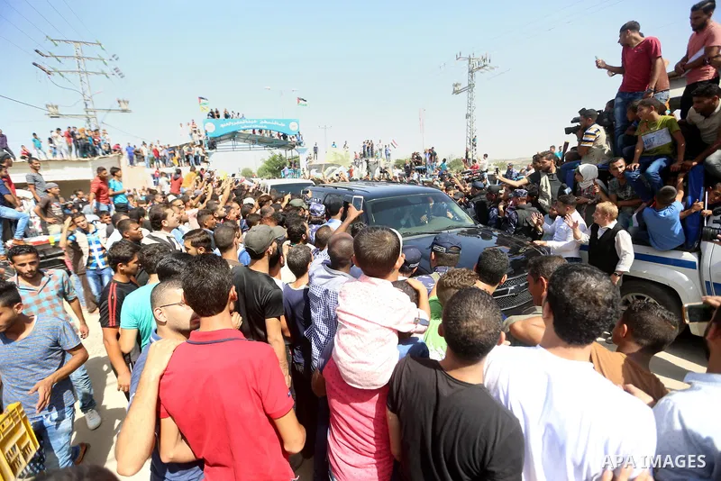 Palestinians celebrate as the convoy of Palestinian Prime Minister Rami Hamdallah and his government ministers arrive to the Erez border crossing in the northern Gaza Strip on October 2, 2017. Hamdallah is on on his firs...