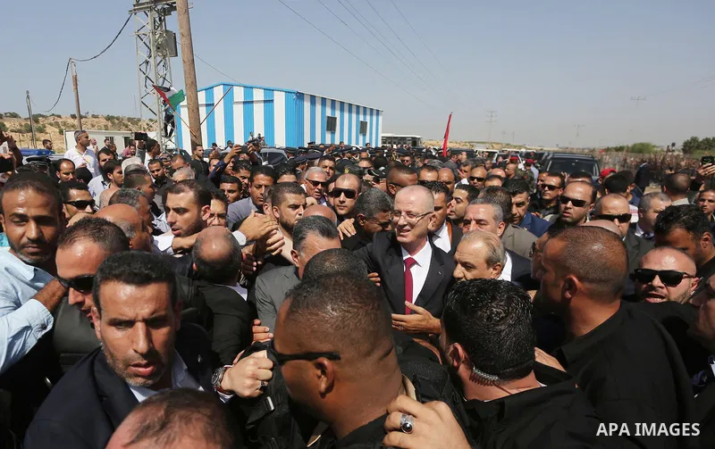 Palestinian Prime Minister Rami Hamdallah is surrounded by security as he waves following his arrival at the Erez border crossing in the northern Gaza Strip on October 2, 2017. Hamdallah is on on his first visit to the G...