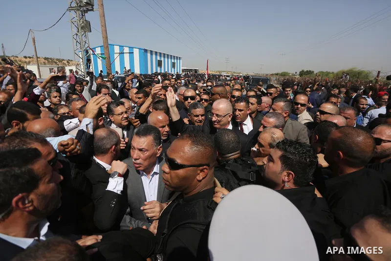 Palestinian Prime Minister Rami Hamdallah is surrounded by security as he waves following his arrival at the Erez border crossing in the northern Gaza Strip on October 2, 2017. Hamdallah is on on his first visit to the G...