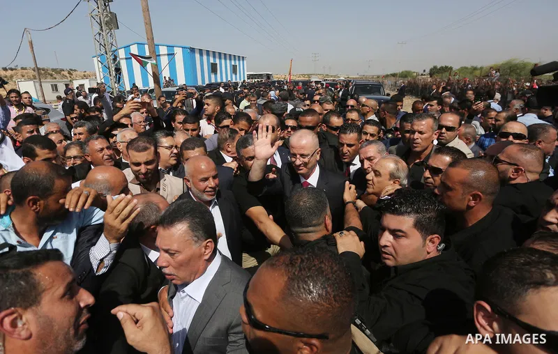 Palestinian Prime Minister Rami Hamdallah is surrounded by security as he waves following his arrival at the Erez border crossing in the northern Gaza Strip on October 2, 2017. Hamdallah is on on his first visit to the G...