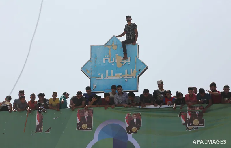 Palestinians gather at the Erez border crossing as Palestinian Prime Minister Rami Hamdallah's convoy arrives in the northern Gaza Strip on October 2, 2017. Hamdallah is on on his first visit to the Gaza Strip for talks...