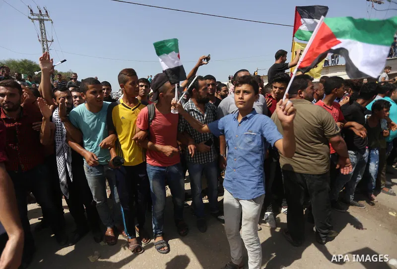 Palestinians celebrate at the Erez border crossing as Palestinian Prime Minister Rami Hamdallah's convoy arrives in the northern Gaza Strip on October 2, 2017. Hamdallah is on on his first visit to the Gaza Strip for tal...