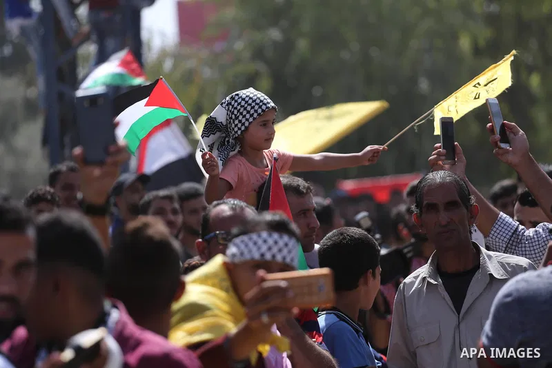 Palestinians celebrate at the Erez border crossing as Palestinian Prime Minister Rami Hamdallah's convoy arrives in the northern Gaza Strip on October 2, 2017. Hamdallah is on on his first visit to the Gaza Strip for tal...