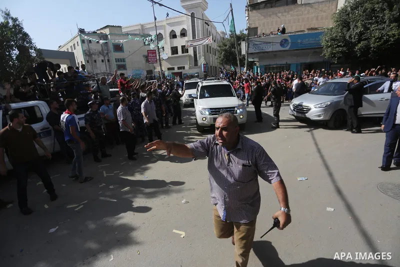 Palestinian Policemen try to hold back the crowd as the convoy of Palestinian Prime Minister Rami Hamdallah arrives to meeting with Hamas Chief Ismail Haniyeh at the house of Ahmed Hilles, top Fatah official in Gaza city...
