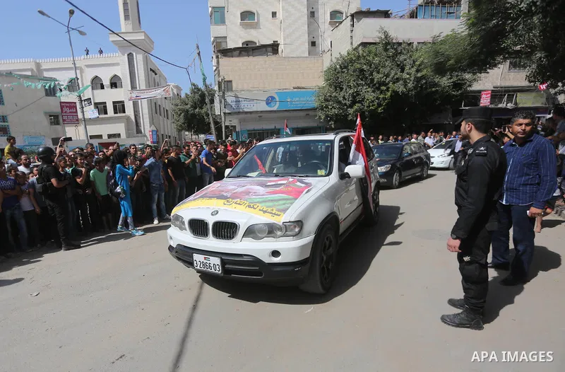 Palestinian Policemen try to hold back the crowd as the convoy of Palestinian Prime Minister Rami Hamdallah arrives to meeting with Hamas Chief Ismail Haniyeh at the house of Ahmed Hilles, top Fatah official in Gaza city...