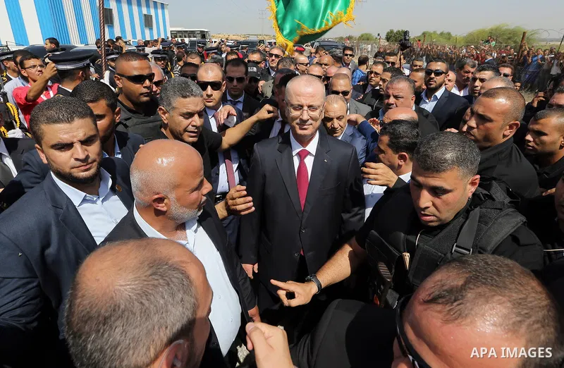 Palestinian Prime Minister Rami Hamdallah is surrounded by security following his arrival at the Erez border crossing in the northern Gaza Strip on October 2, 2017. Hamdallah is on on his first visit to the Gaza Strip fo...