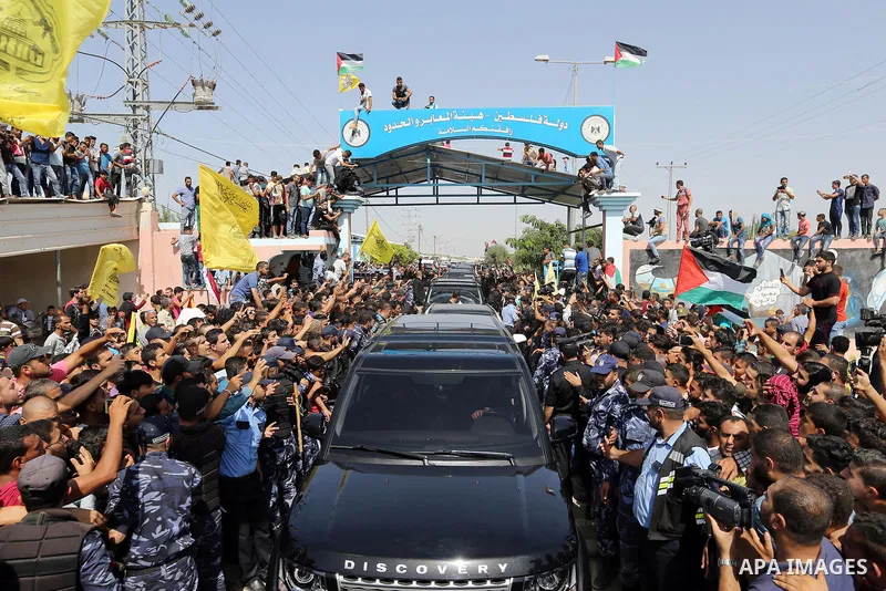 Palestinians celebrate as the convoy of Palestinian Prime Minister Rami Hamdallah and his government ministers arrive to the Erez border crossing in the northern Gaza Strip on October 2, 2017. Hamdallah is on on his firs...