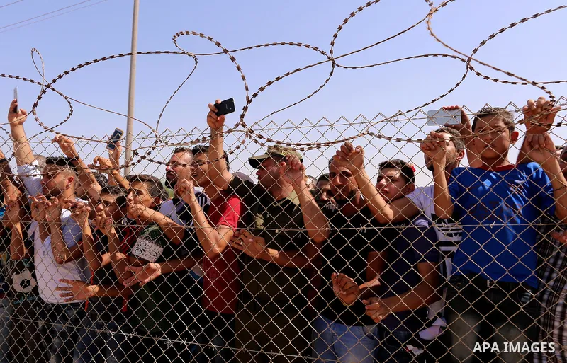 Palestinians celebrate at the Erez border crossing as Palestinian Prime Minister Rami Hamdallah's convoy arrives in the northern Gaza Strip on October 2, 2017. Palestinian prime minister Rami Hamdallah arrived in Gaza fo...