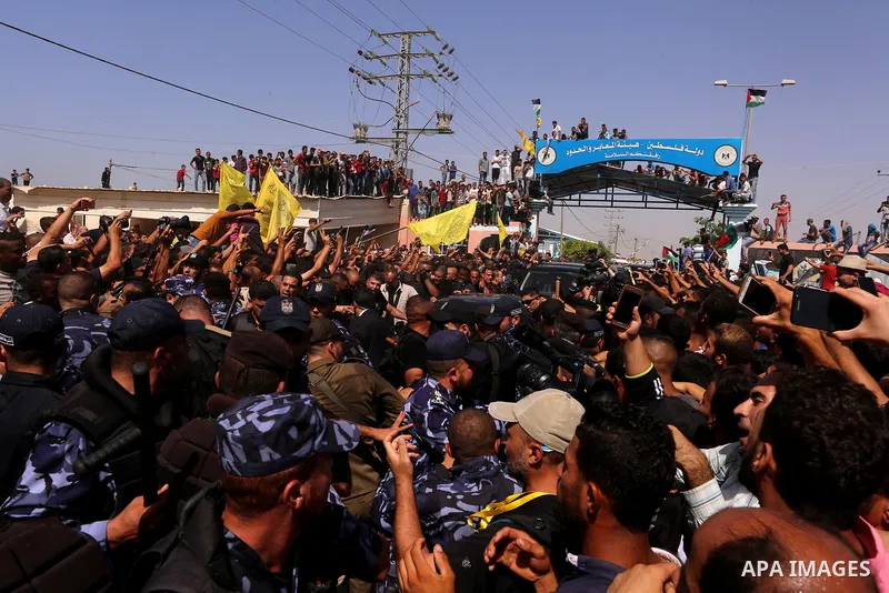 Palestinian Policemen try to hold back the crowd as the convoy of Palestinian Prime Minister Rami Hamdallah arrives to the Erez border crossing in the northern Gaza Strip on October 2, 2017. Palestinian prime minister Ra...