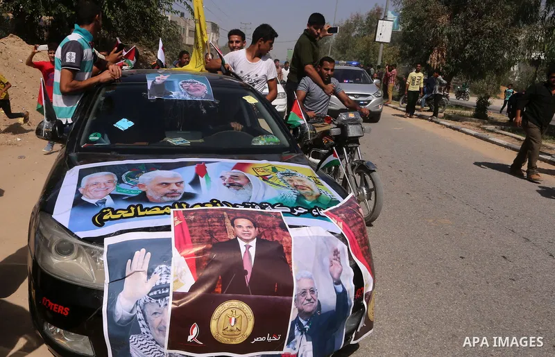 Palestinians celebrate at the Erez border crossing as Palestinian Prime Minister Rami Hamdallah's convoy arrives in the northern Gaza Strip on October 2, 2017. Palestinian prime minister Rami Hamdallah arrived in Gaza fo...