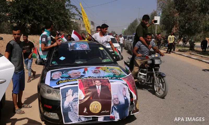 Palestinians celebrate at the Erez border crossing as Palestinian Prime Minister Rami Hamdallah's convoy arrives in the northern Gaza Strip on October 2, 2017. Palestinian prime minister Rami Hamdallah arrived in Gaza fo...