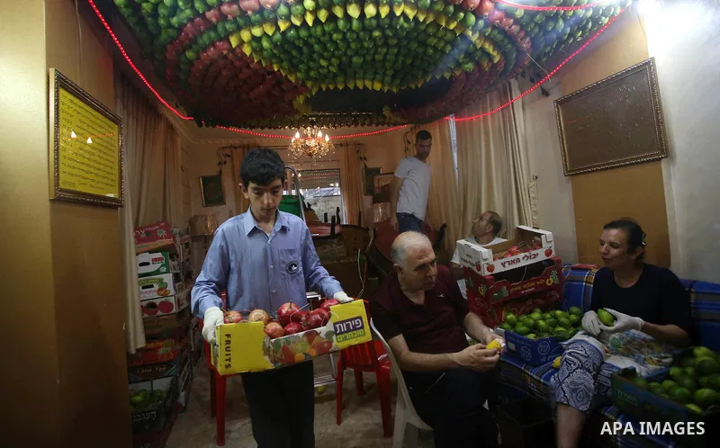 A member of the Samaritan sect decorates a traditional hut known as a sukkot with fruits and vegetables on Mount Gerizim, on the outskirts of the West Bank city of Nablus, October 2, 2017. A sukkot is a ritual hut used d...