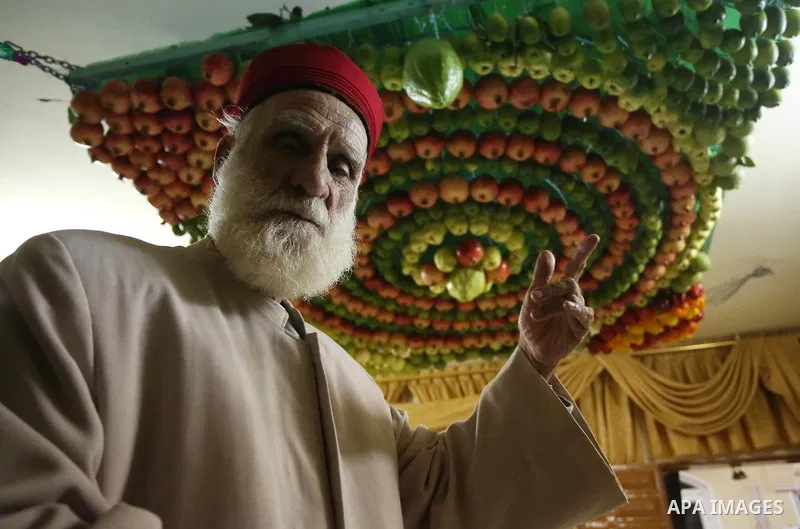 A member of the Samaritan sect decorates a traditional hut known as a sukkot with fruits and vegetables on Mount Gerizim, on the outskirts of the West Bank city of Nablus, October 2, 2017. A sukkot is a ritual hut used d...