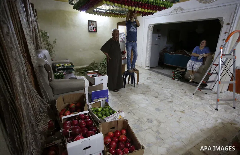 A member of the Samaritan sect decorates a traditional hut known as a sukkot with fruits and vegetables on Mount Gerizim, on the outskirts of the West Bank city of Nablus, October 2, 2017. A sukkot is a ritual hut used d...