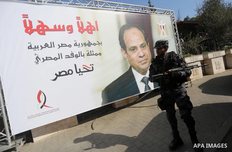 A member of Palestinian security forces stands guards next to a billboard bearing the portrait of Egyptian President Abdel Fattah al-Sisi near the Palestinian government headquarters in Gaza City on October 3, 2017. Phot...