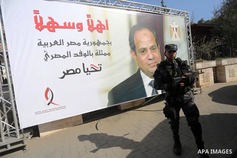 A member of Palestinian security forces stands guards next to a billboard bearing the portrait of Egyptian President Abdel Fattah al-Sisi near the Palestinian government headquarters in Gaza City on October 3, 2017. Phot...