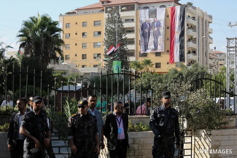 Palestinian security forces in Gaza strip stand guard as an Egyptian flag with a big poster of Palestinian President Mahmoud Abbas and Egyptian President Abdel Fattah Al-Sisi hang from a building near the Palestinian gov...