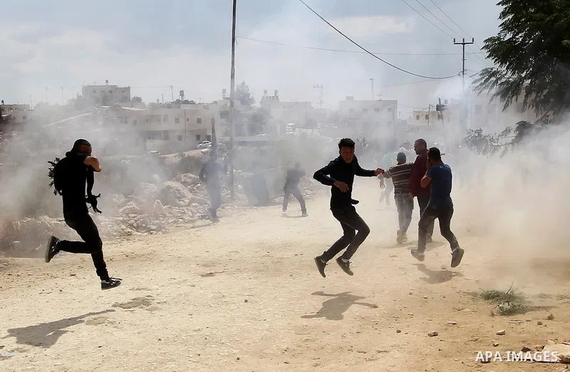 Palestinian protesters run for cover during clashes with Israeli security forces at a protest demanding the reopening of the main road to the Qalqas village that was closed by Israel almost 17 years ago in the West Bank...