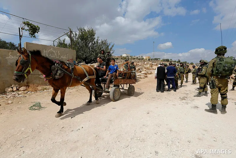 Palestinian protesters take part during a protest demanding the reopening of the main road to the Qalqas village that was closed by Israel almost 17 years ago in the West Bank city of Hebron October 6, 2017. Photo by Wis...