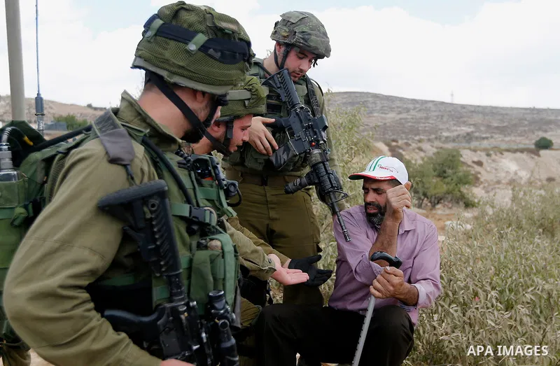 A Palestinian protester argues with Israeli security forces during a protest demanding the reopening of the main road to the Qalqas village that was closed by Israel almost 17 years ago in the West Bank city of Hebron Oc...