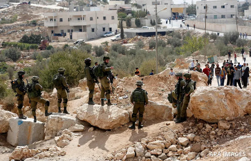 Israeli security forces take position during a protest by Palestinians demanding the reopening of the main road to the Qalqas village that was closed by Israel almost 17 years ago in the West Bank city of Hebron October...