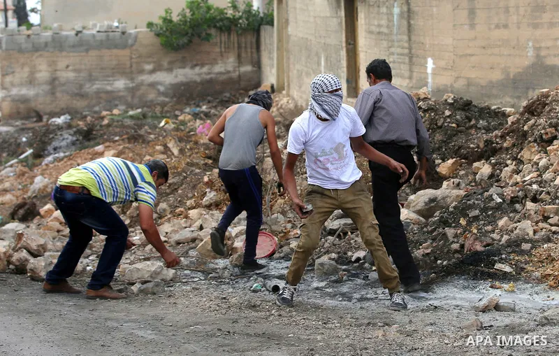 Palestinian protesters throw stones towards Israeli security forces during clashes following a demonstration against the expropriation of Palestinian land by Israel in the village of Kfar Qaddum, near Nablus in the occup...